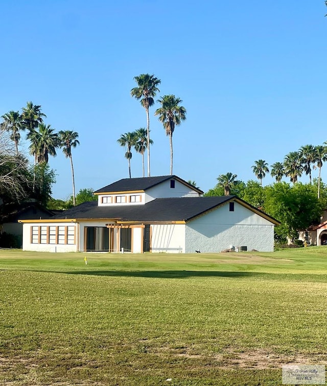 rear view of house featuring a lawn