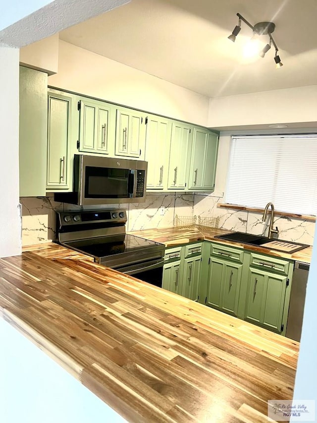 kitchen with sink, stainless steel appliances, and green cabinetry