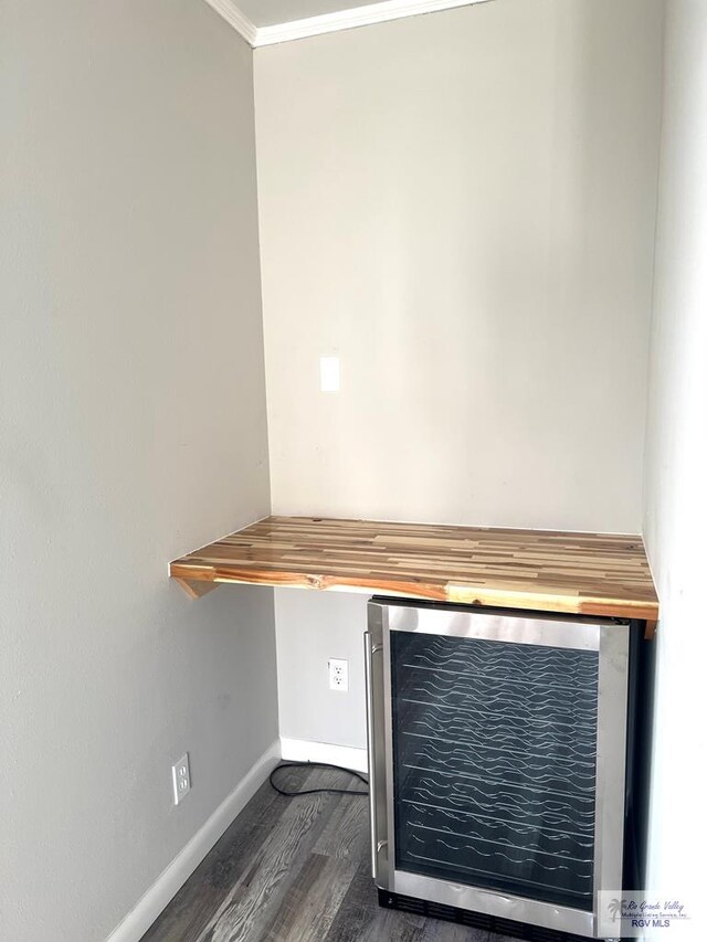 room details with wine cooler, crown molding, and hardwood / wood-style flooring