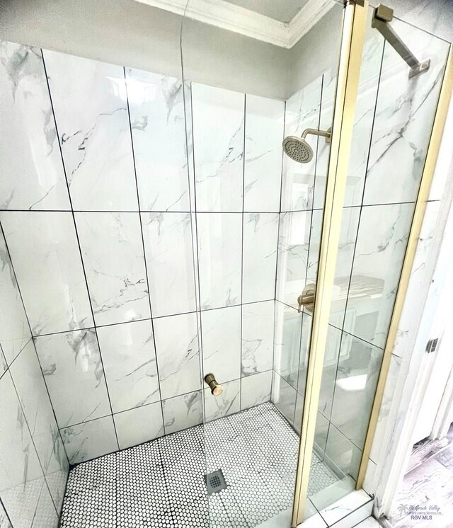 bathroom featuring crown molding and an enclosed shower