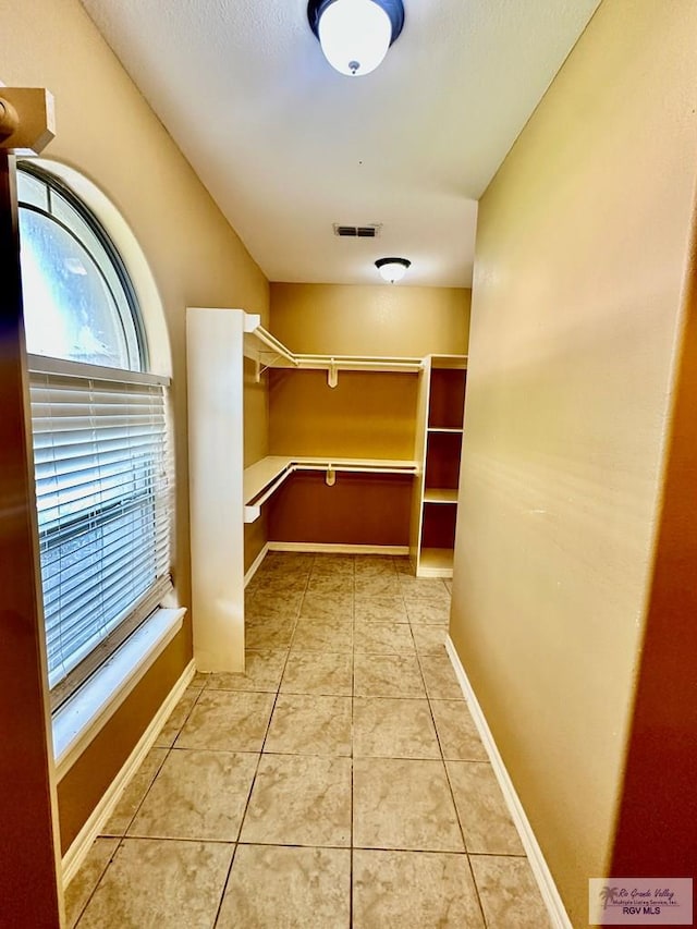 walk in closet with light tile patterned floors