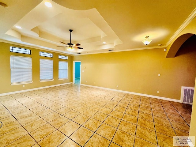 tiled spare room with a raised ceiling, ceiling fan, and crown molding