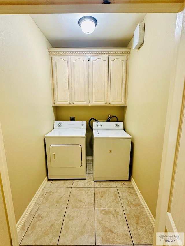 clothes washing area with cabinets, independent washer and dryer, and light tile patterned flooring