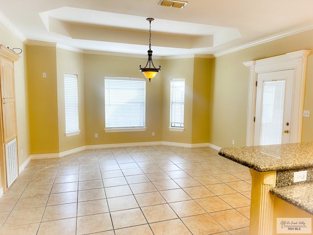 unfurnished dining area featuring a raised ceiling, light tile patterned floors, and crown molding