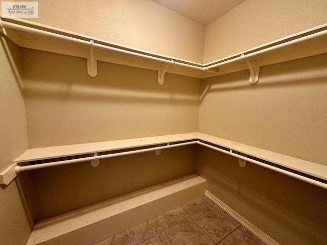 walk in closet with tile patterned flooring