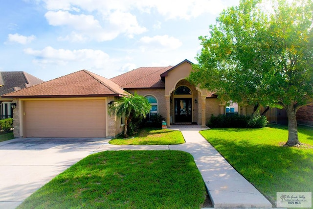 mediterranean / spanish home with a front lawn and a garage