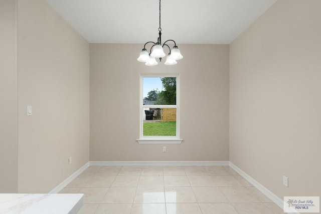 unfurnished dining area featuring an inviting chandelier and light tile patterned flooring