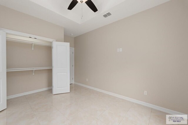 unfurnished bedroom featuring light tile patterned floors, a closet, ceiling fan, and lofted ceiling