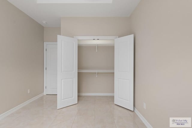 unfurnished bedroom featuring light tile patterned floors and a closet