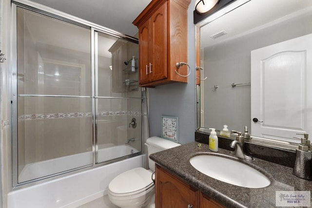 full bathroom featuring enclosed tub / shower combo, vanity, and toilet