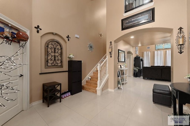 foyer entrance with a towering ceiling and tile patterned floors