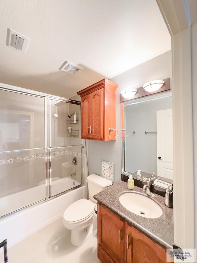 full bathroom featuring vanity, bath / shower combo with glass door, and toilet