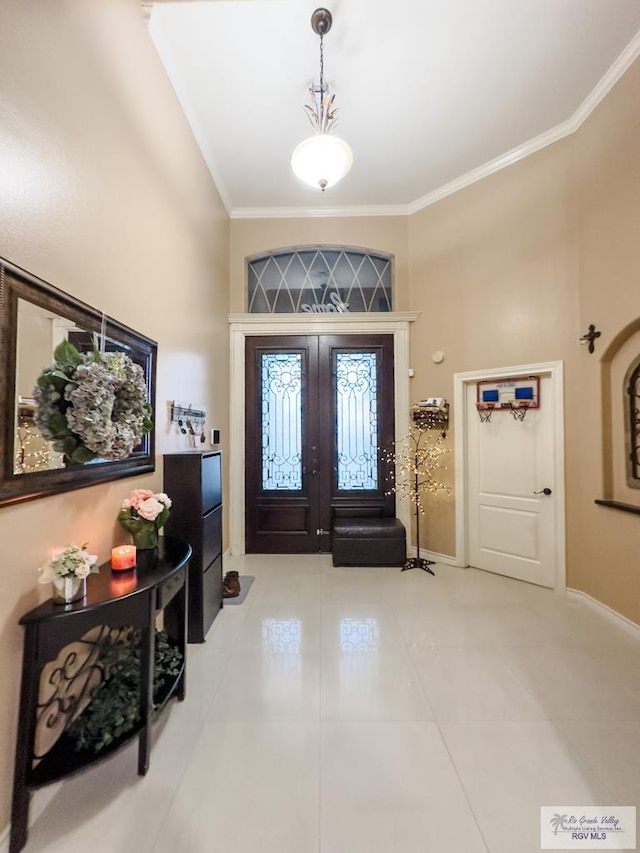 tiled entryway with crown molding and french doors