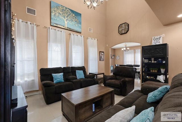 living room featuring a towering ceiling and an inviting chandelier