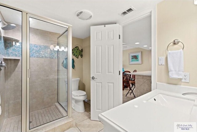 bathroom featuring tile patterned flooring, a shower with door, and toilet