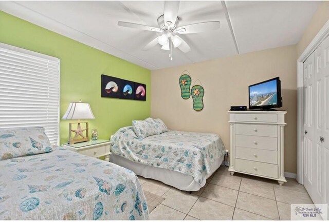 bedroom featuring light tile patterned floors, a closet, and ceiling fan