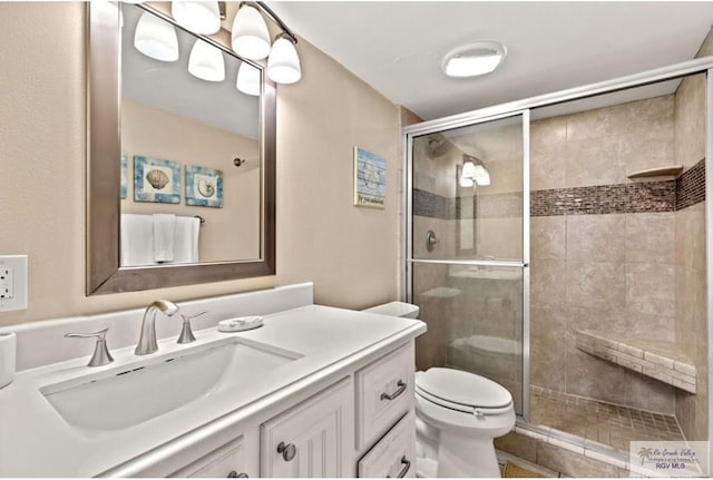 bathroom featuring vanity, an enclosed shower, and toilet