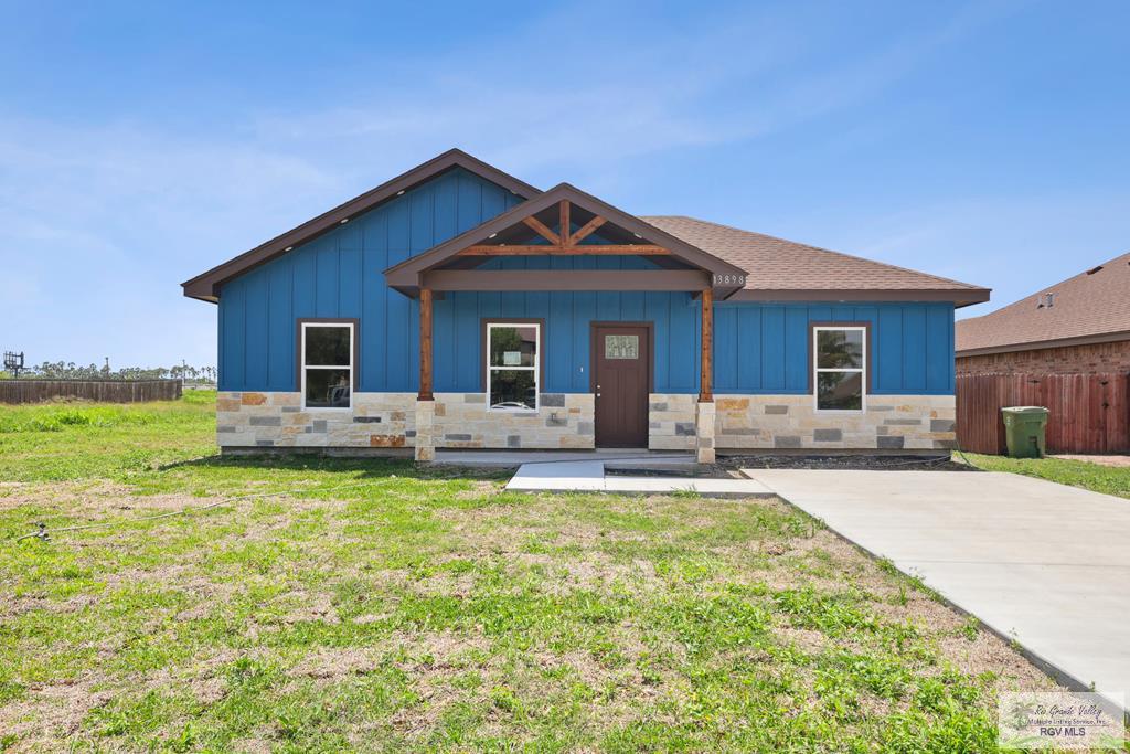13898 Isaiah Ct Unit 4, La Feria, TX 78559 - view of front of property featuring a front lawn, fence, and stone siding