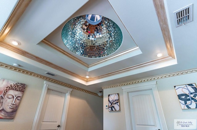 room details featuring visible vents, a tray ceiling, and crown molding