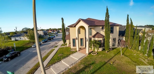 view of front facade with a front yard and stucco siding