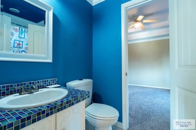 bathroom featuring crown molding, toilet, ceiling fan, vanity, and baseboards