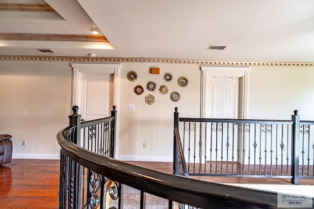 corridor featuring baseboards, visible vents, dark wood-type flooring, and an upstairs landing