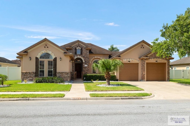 5713 Spicewood, Harlingen, TX 78552 - mediterranean / spanish house featuring brick siding, an attached garage, concrete driveway, and stucco siding
