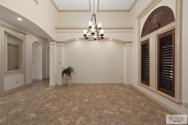 5713 Spicewood, Harlingen, TX 78552 - spare room with arched walkways, a chandelier, and stone finish flooring