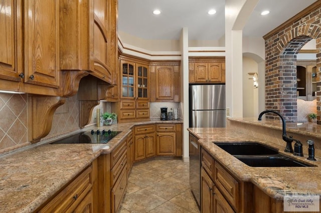 5713 Spicewood, Harlingen, TX 78552 - kitchen with stainless steel appliances, a sink, brown cabinetry, tasteful backsplash, and recessed lighting