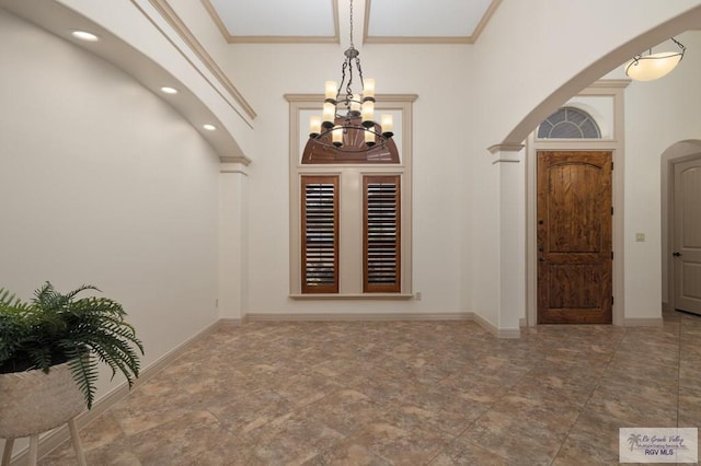5713 Spicewood, Harlingen, TX 78552 - entryway with arched walkways, a chandelier, baseboards, stone finish floors, and ornamental molding