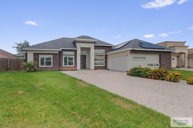 prairie-style home with solar panels, a garage, and a front lawn