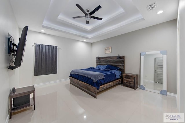 bedroom with a raised ceiling, ceiling fan, and tile patterned flooring