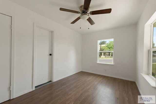 unfurnished room featuring ceiling fan and dark wood-type flooring