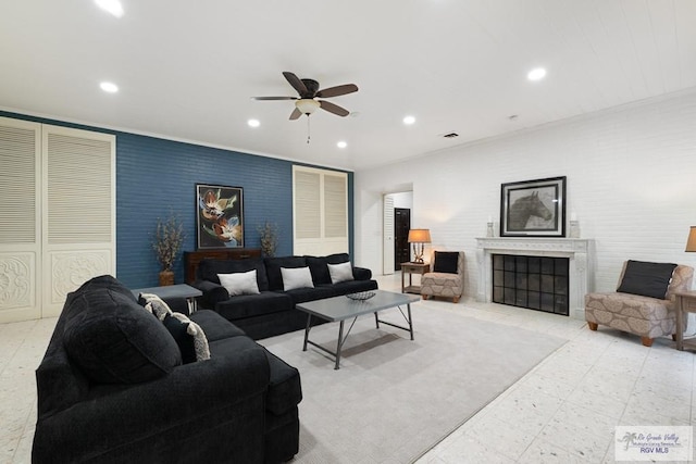 living room featuring recessed lighting, an accent wall, a ceiling fan, and a high end fireplace