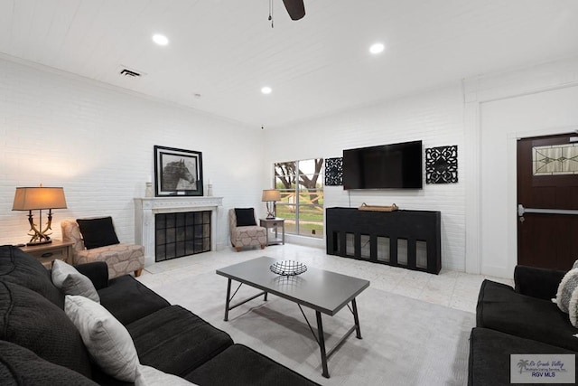 living area featuring light tile patterned flooring, recessed lighting, visible vents, and a tile fireplace