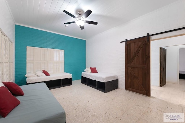 bedroom featuring a barn door, brick wall, a ceiling fan, ornamental molding, and light floors