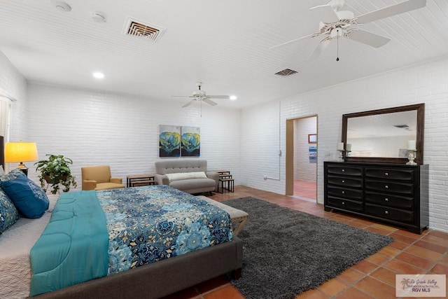 tiled bedroom featuring visible vents, ceiling fan, and brick wall