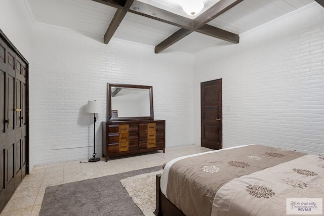 bedroom featuring brick wall and beam ceiling