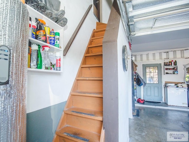 staircase featuring concrete floors