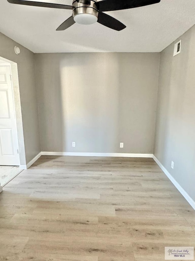 unfurnished room featuring visible vents, baseboards, ceiling fan, and wood finished floors