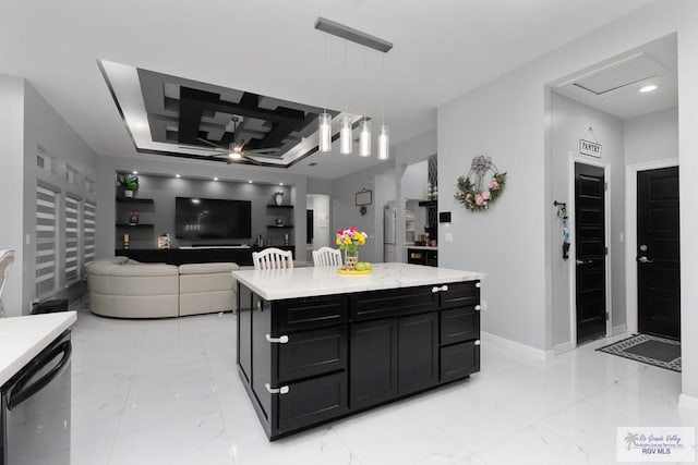 711 Santa Elena St, Weslaco, TX 78596 - kitchen with light countertops, dark cabinetry, light marble finish flooring, and decorative light fixtures