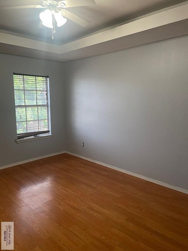 2776 Fleet St, Brownsville, TX 78521 - unfurnished room featuring wood finished floors, baseboards, a tray ceiling, and a ceiling fan