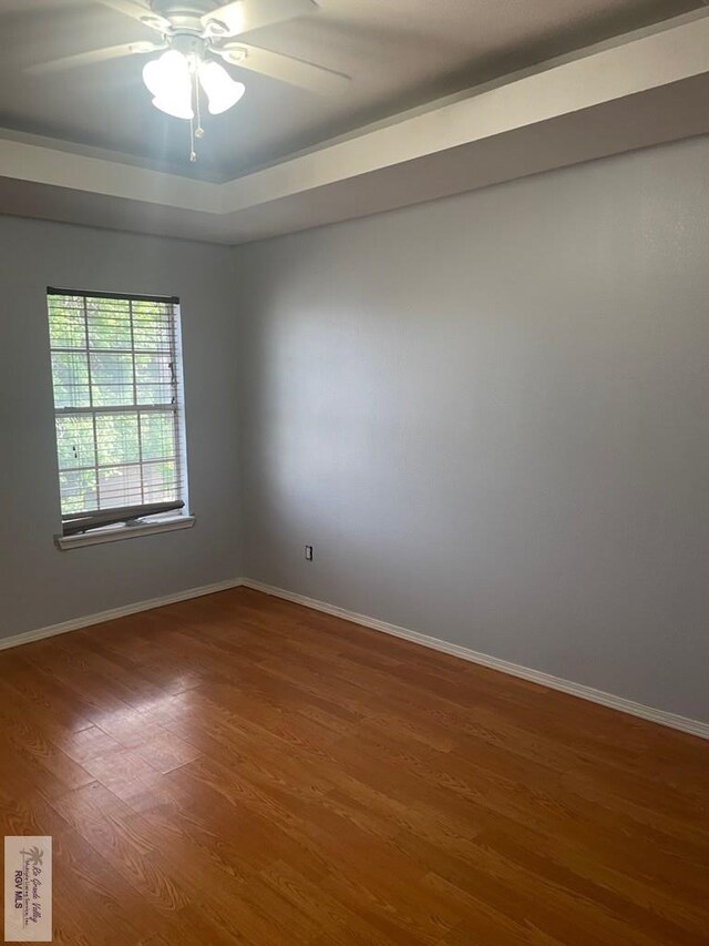 2776 Fleet St, Brownsville, TX 78521 - empty room with wood finished floors, baseboards, ceiling fan, and a tray ceiling