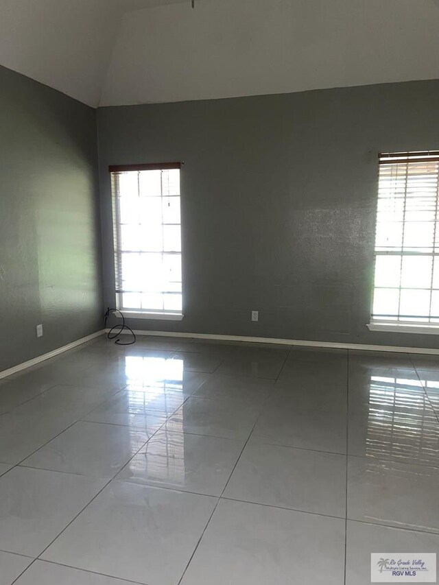 2776 Fleet St, Brownsville, TX 78521 - unfurnished room featuring healthy amount of natural light, tile patterned floors, vaulted ceiling, and baseboards