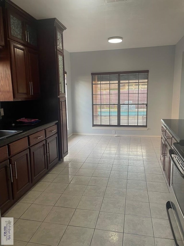 2776 Fleet St, Brownsville, TX 78521 - kitchen with dark countertops, light tile patterned flooring, and stainless steel range oven