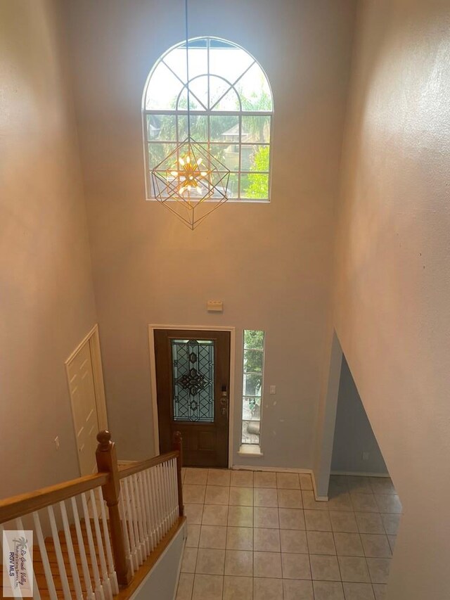 2776 Fleet St, Brownsville, TX 78521 - foyer entrance with a towering ceiling, light tile patterned flooring, healthy amount of natural light, and a chandelier