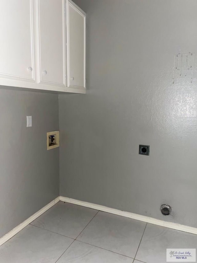 2776 Fleet St, Brownsville, TX 78521 - laundry area with hookup for an electric dryer, washer hookup, light tile patterned floors, cabinet space, and baseboards