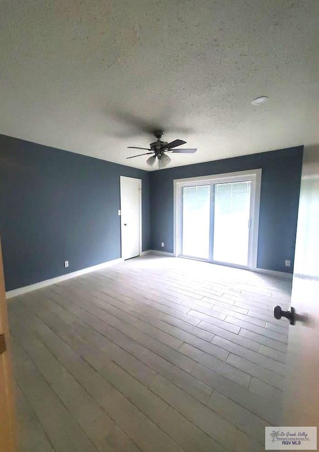 spare room featuring ceiling fan, a textured ceiling, and light wood-type flooring