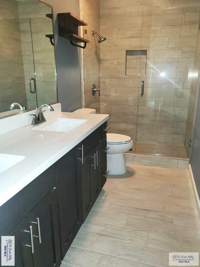 bathroom featuring vanity, an enclosed shower, and toilet