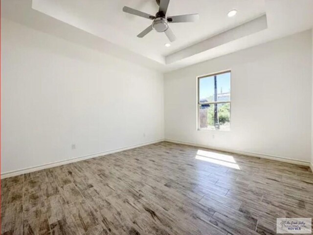 17134 Mandarin Ave, Harlingen, TX 78552 - spare room featuring a tray ceiling, wood finished floors, baseboards, a ceiling fan, and recessed lighting